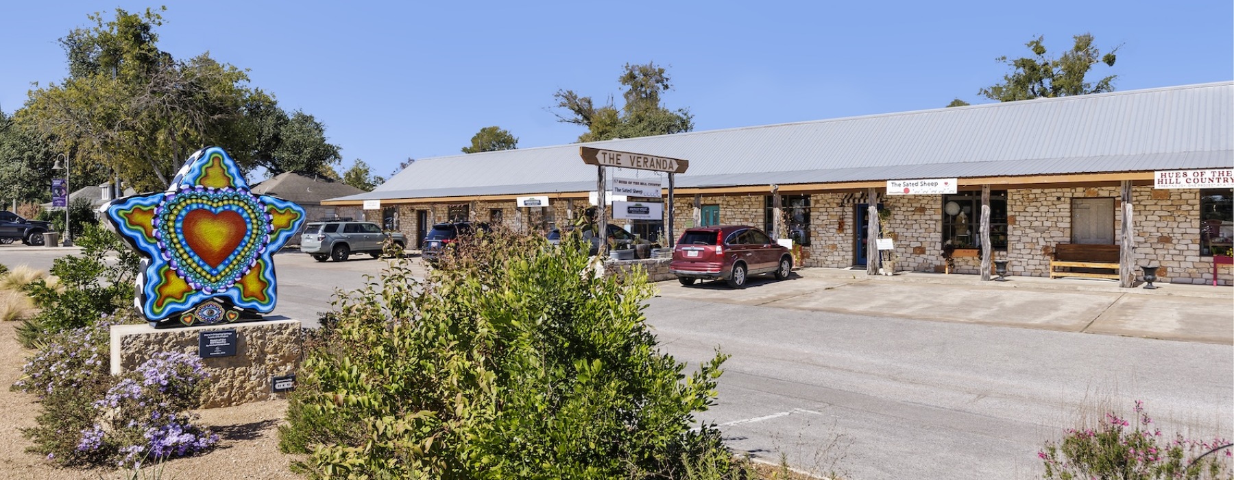 a storefront of shops and boutiques with a Dripping Springs star